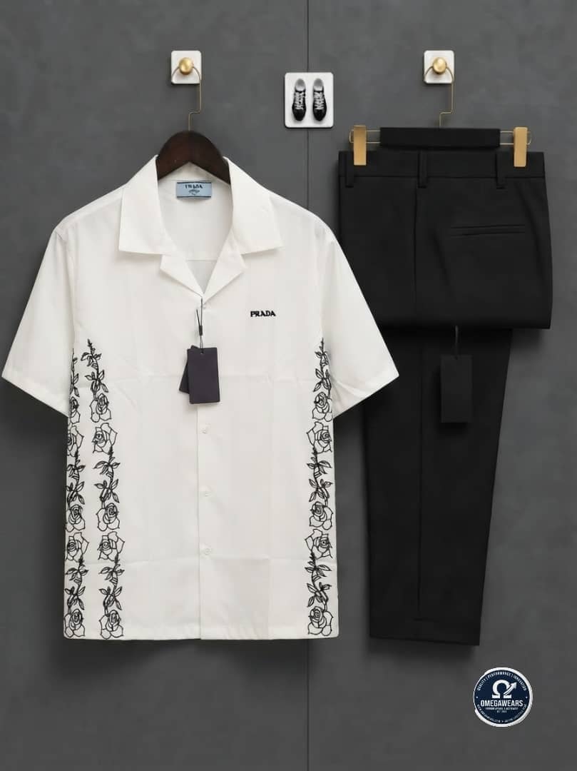 White shirt with rose embroidery on sides and black trousers.