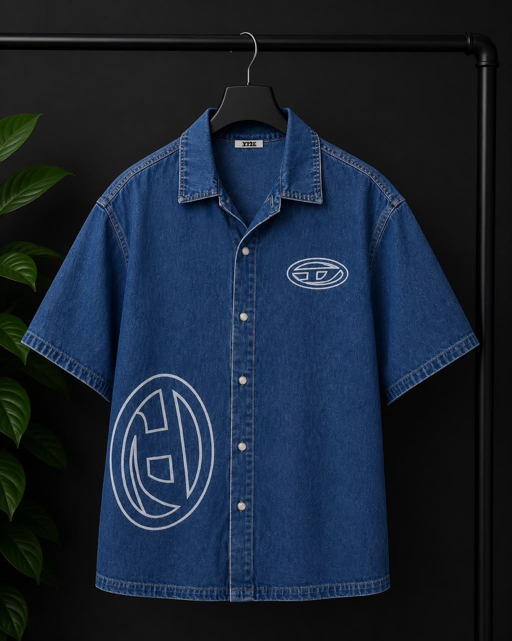Blue denim short-sleeve button-up shirt with large white circular logo print on front.
