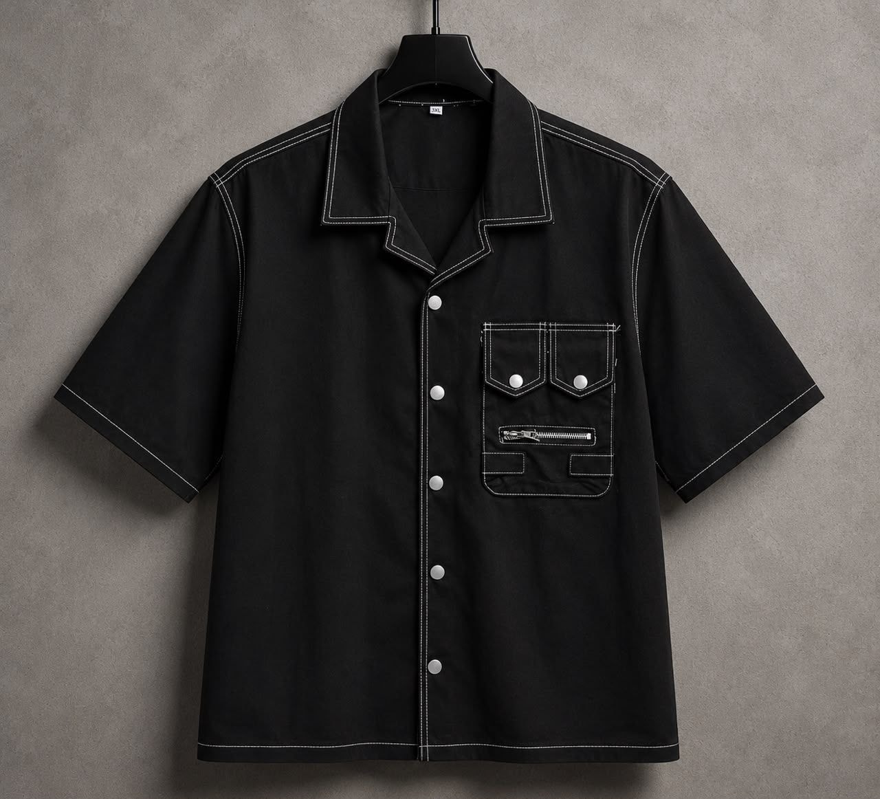 Black short-sleeve denim shirt with white contrast stitching, buttons and zippered chest pockets.