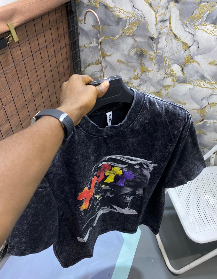 Black stone wash t-shirt with black and white face portrait and multicolored floral X graphic.