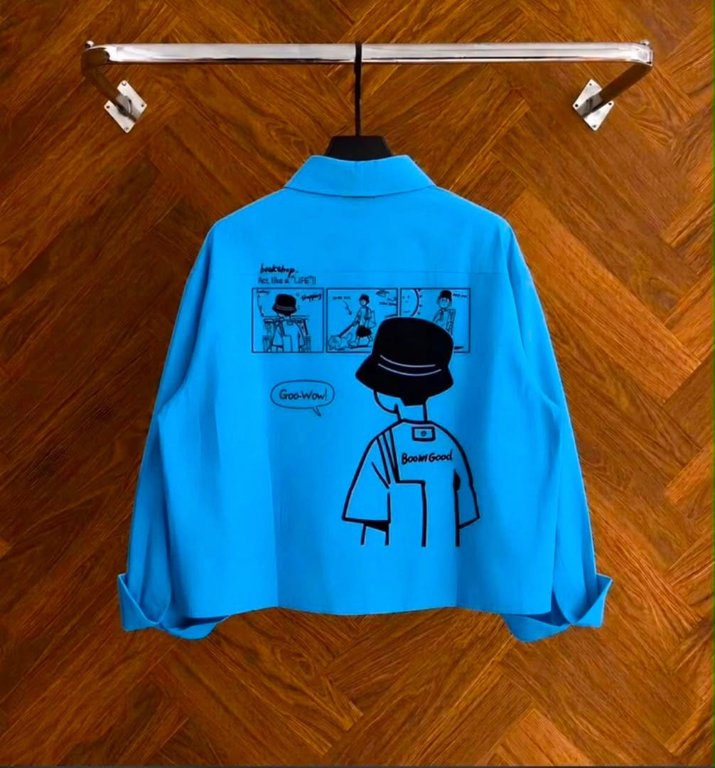 Back view of blue cropped shirt displaying comic graphic print and text.
