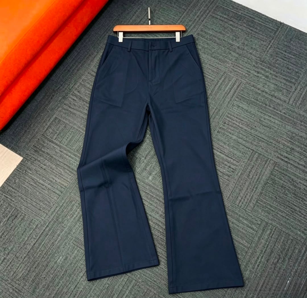 Navy flare trousers displayed flat on gray patterned surface.