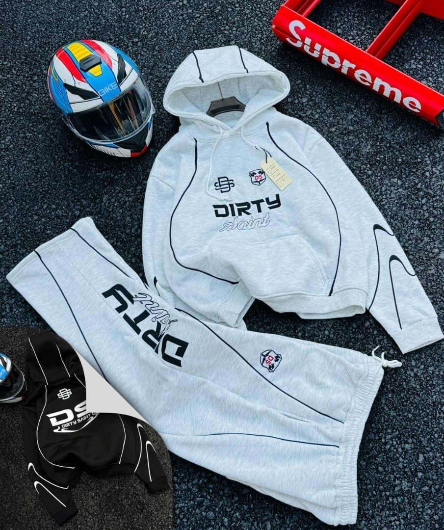 Light gray Dirty Saint hoodie and pants set with helmet accessory on asphalt.