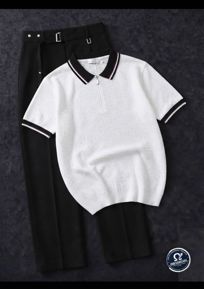White knitted polo with black trim and black pleated trousers.