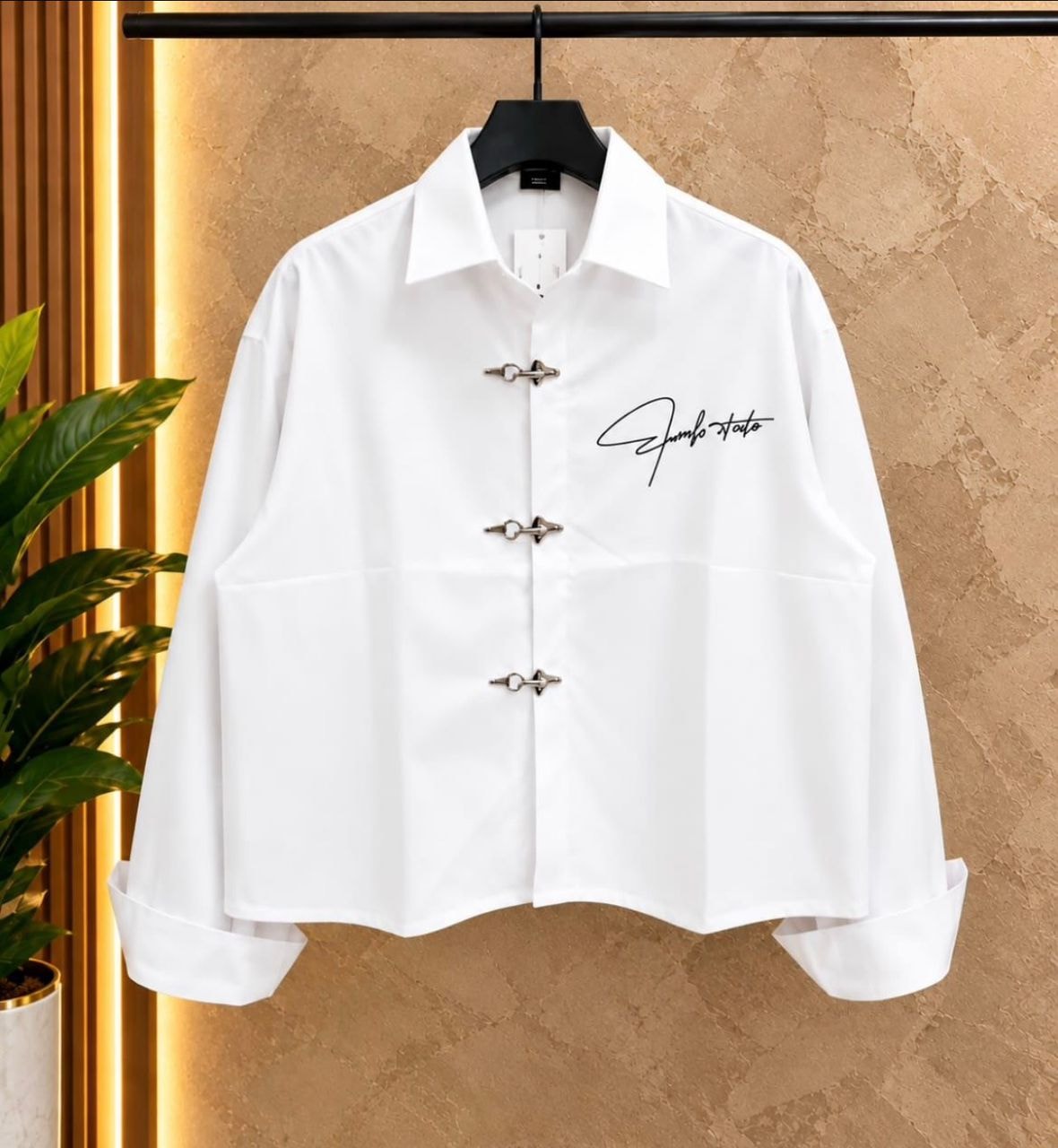 Front view of white cropped toggle button shirt on hanger.