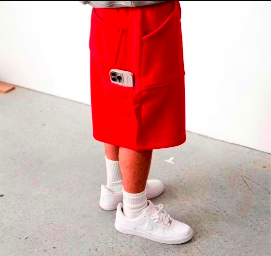 Model in red fleece shorts with thigh phone pocket, white socks and sneakers.
