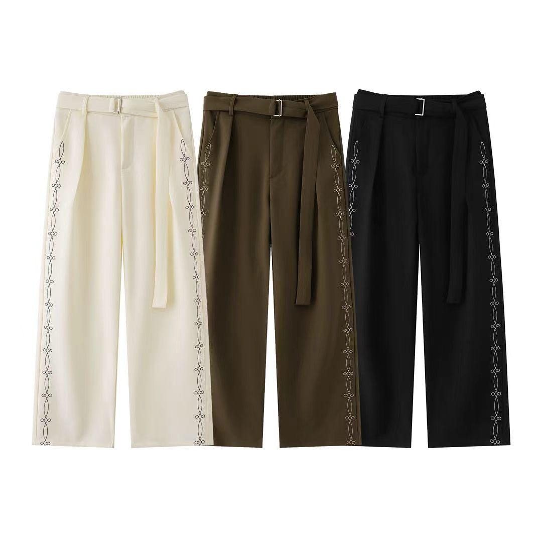 Three wide-leg trousers with side embroidery in cream, olive, and black with belts.