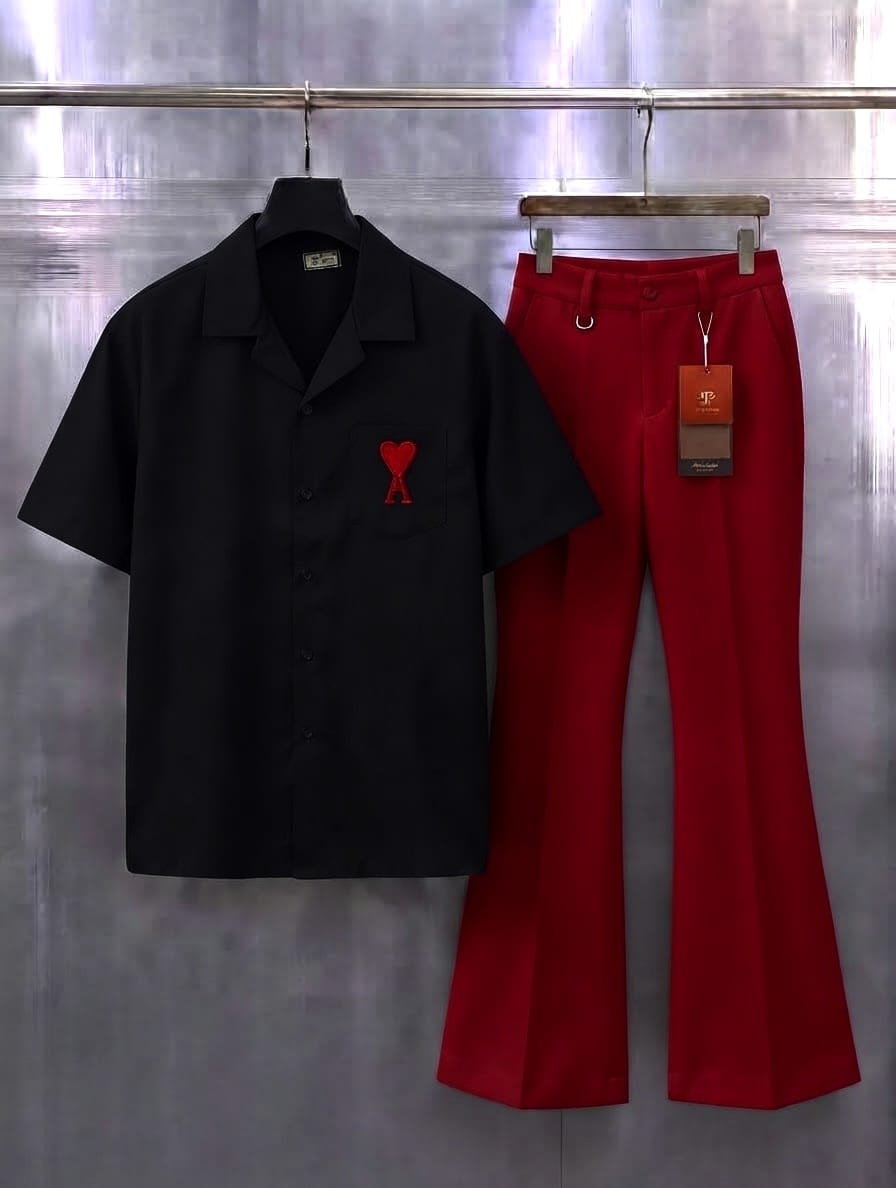 Black short-sleeve button-up shirt with red embroidery and red pleated flare trousers hanging side by side.