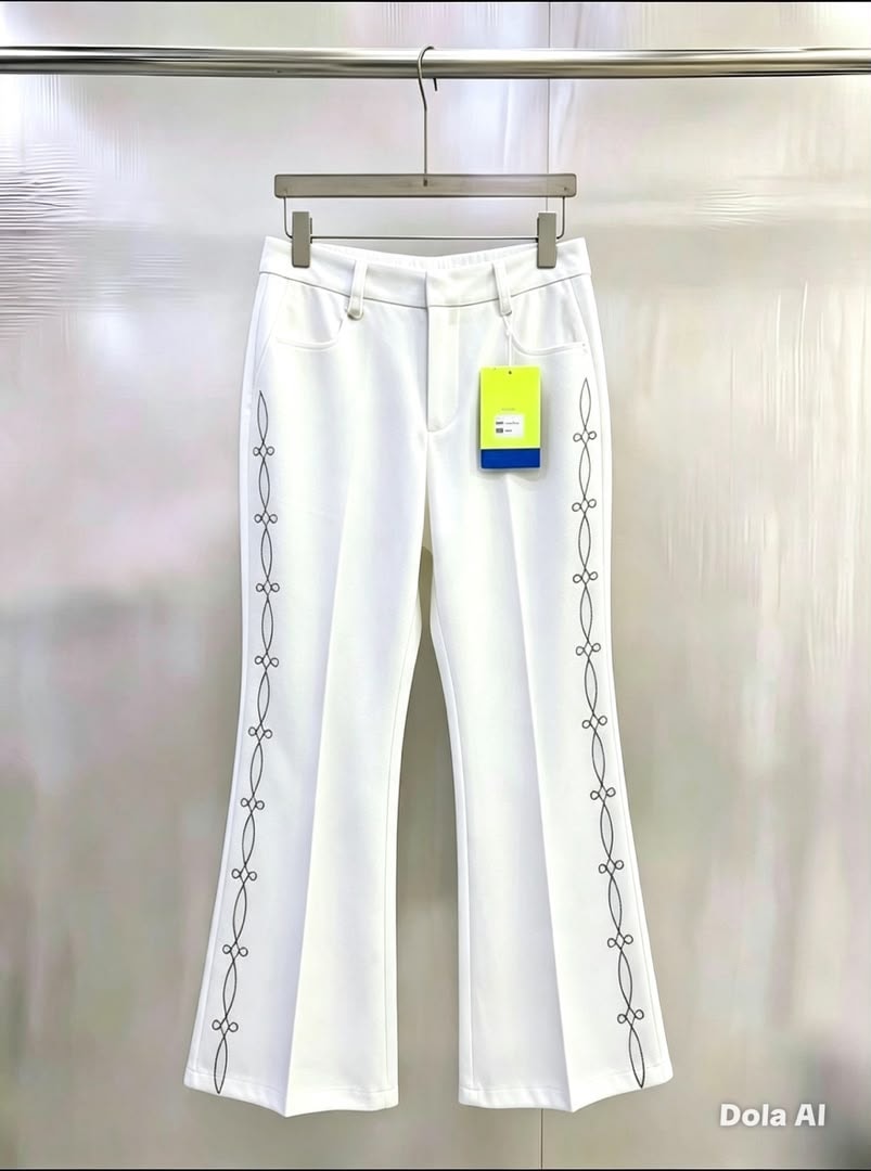 White flare trousers with black chain embroidery along the side seams.