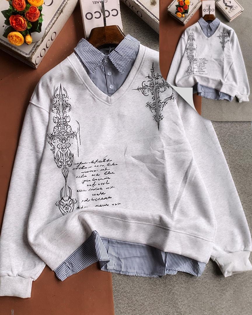 White V-neck sweatshirt with black ornate cross and cursive script print, shown with inset view and striped layering.