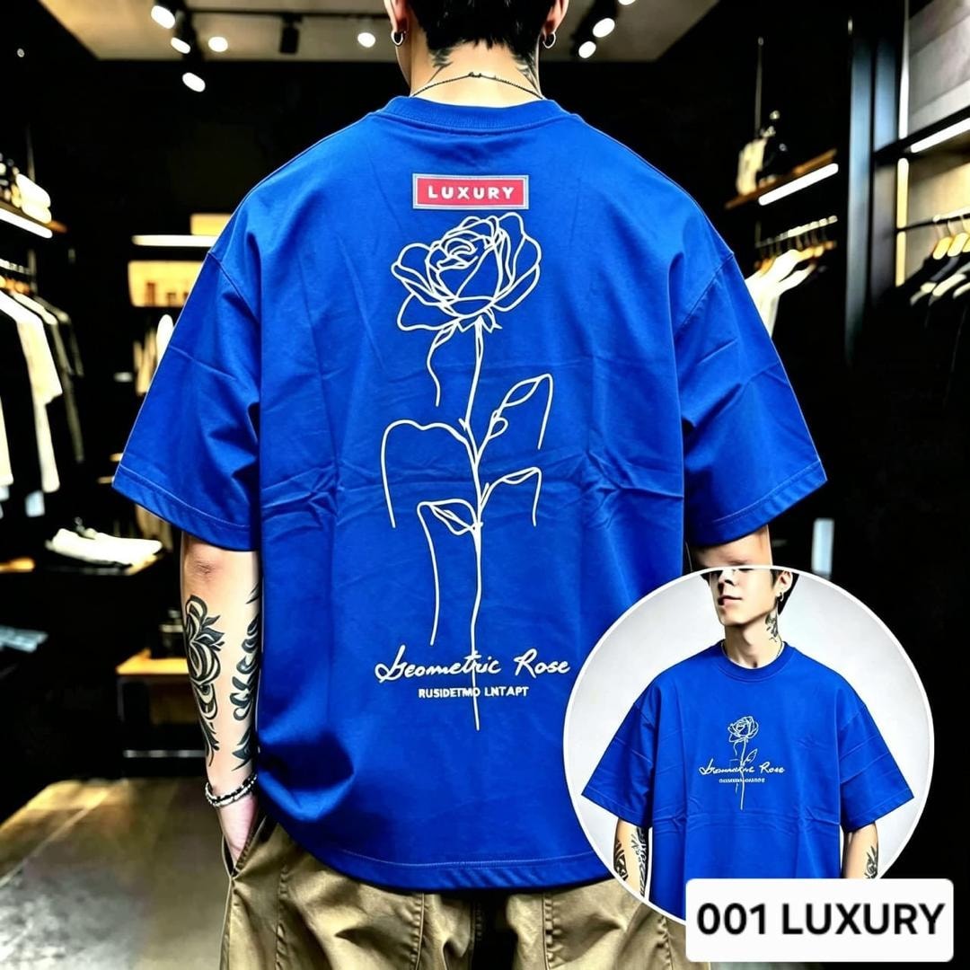 Man modeling blue oversized t-shirt with geometric rose line art on the back.
