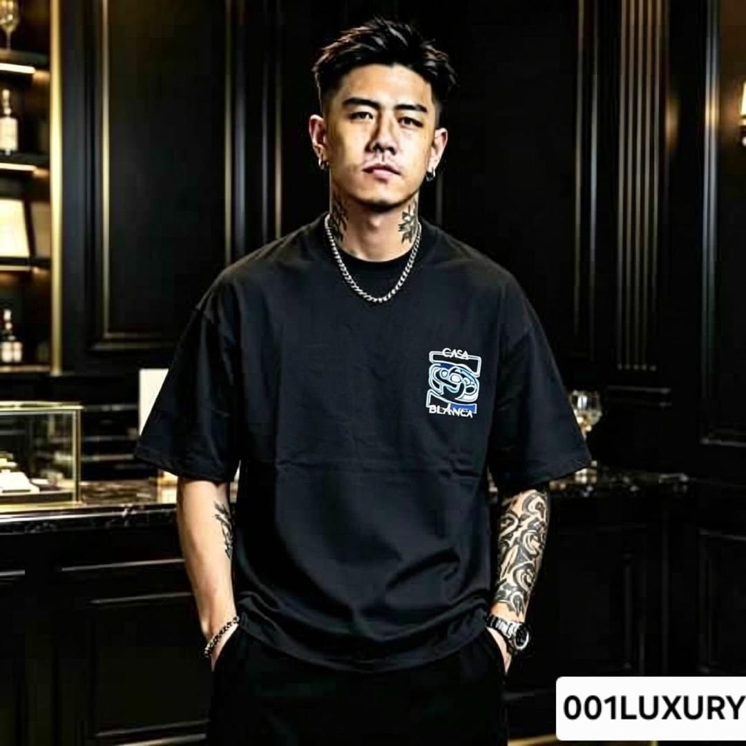 Man modeling black oversized t-shirt with Casa Blanca logo on chest.