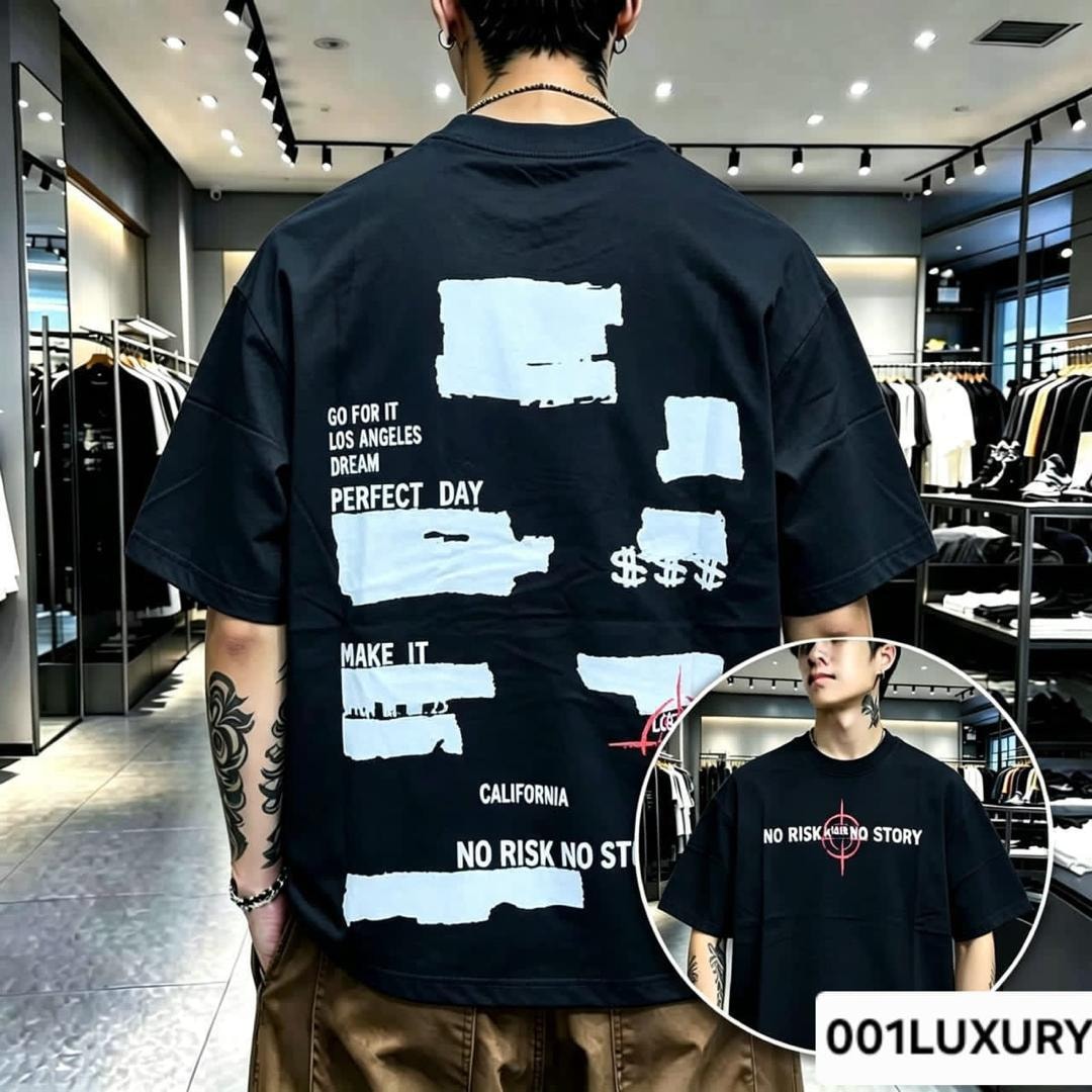 Man in black oversized T-shirt with white torn paper text collage on the back.