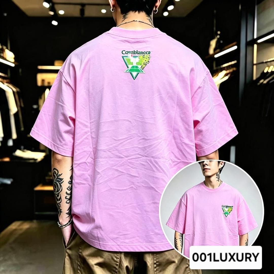 Man in pink oversized T-shirt with Casablanca logo graphic on the back.