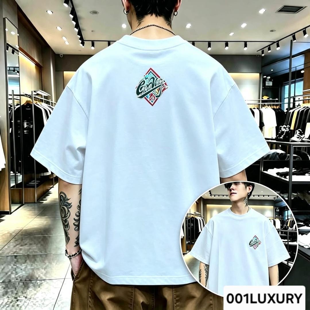 Man in white oversized T-shirt showing diamond logo graphic on the back.