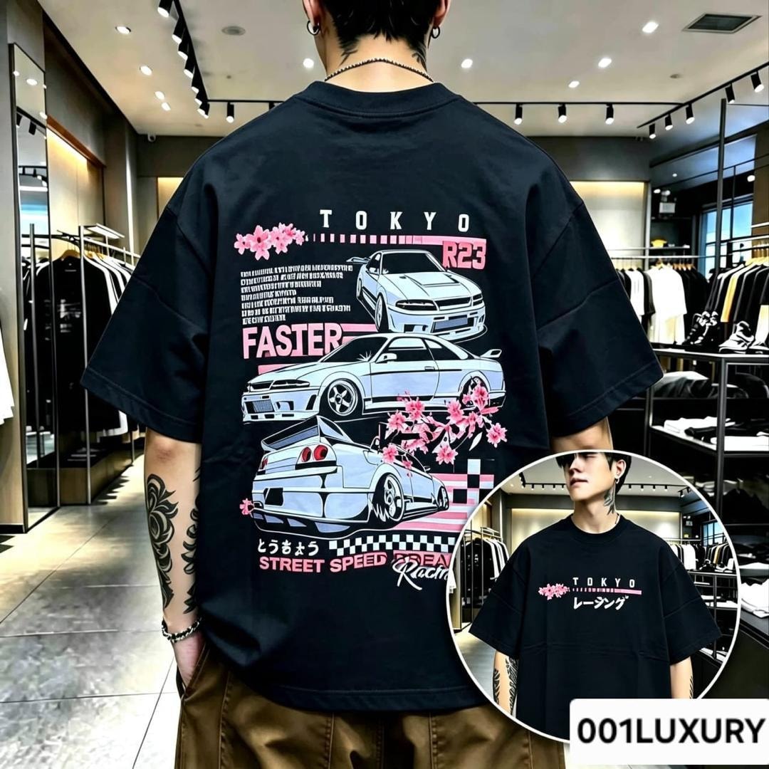 Man in black oversized T-shirt with Tokyo racing cars, cherry blossoms and text graphics on the back.
