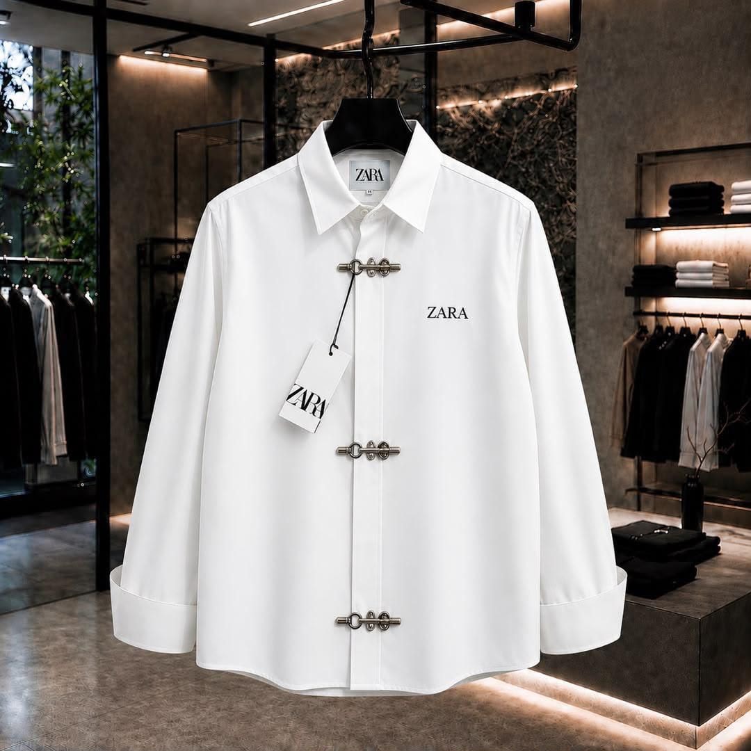 White ZARA long sleeve shirt with toggle closures and chest logo in showroom.
