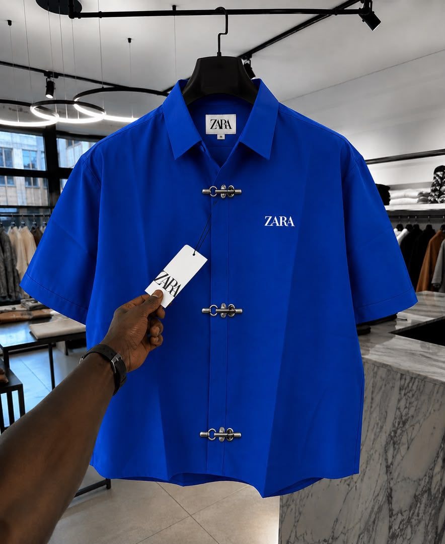 Blue ZARA short sleeve shirt with toggle closures and chest logo.