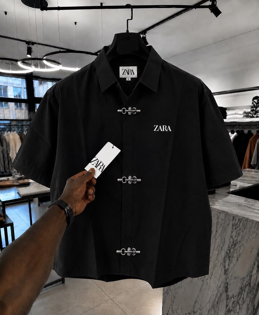 Black ZARA short sleeve shirt with toggle closures and chest logo.