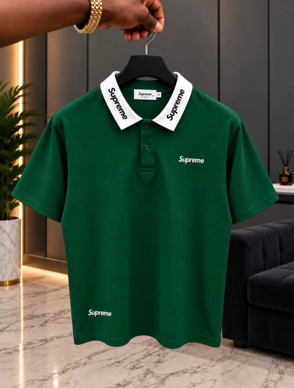 Green Supreme polo shirt with white collar on hanger.