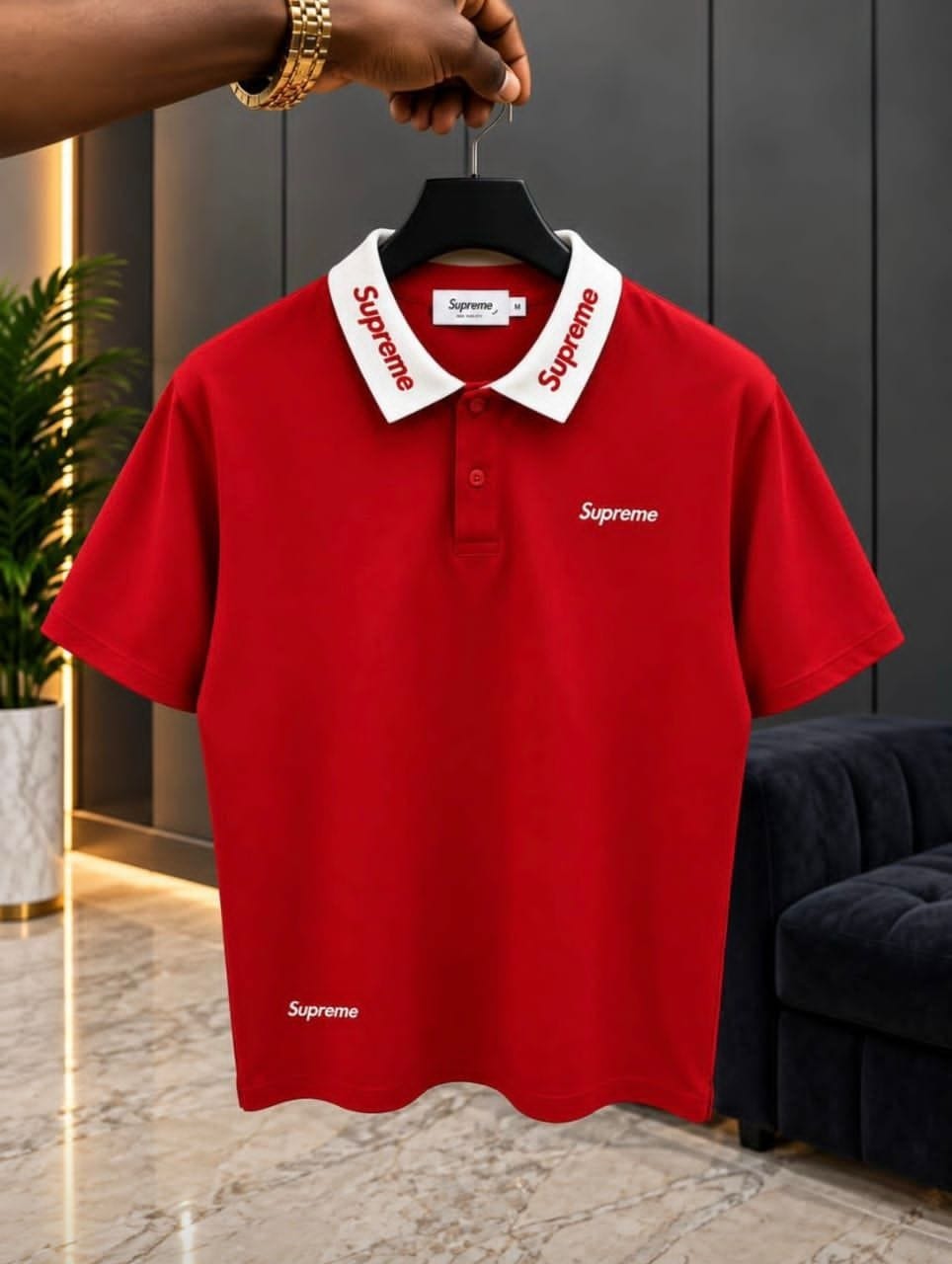 Red Supreme polo shirt with white collar on hanger.