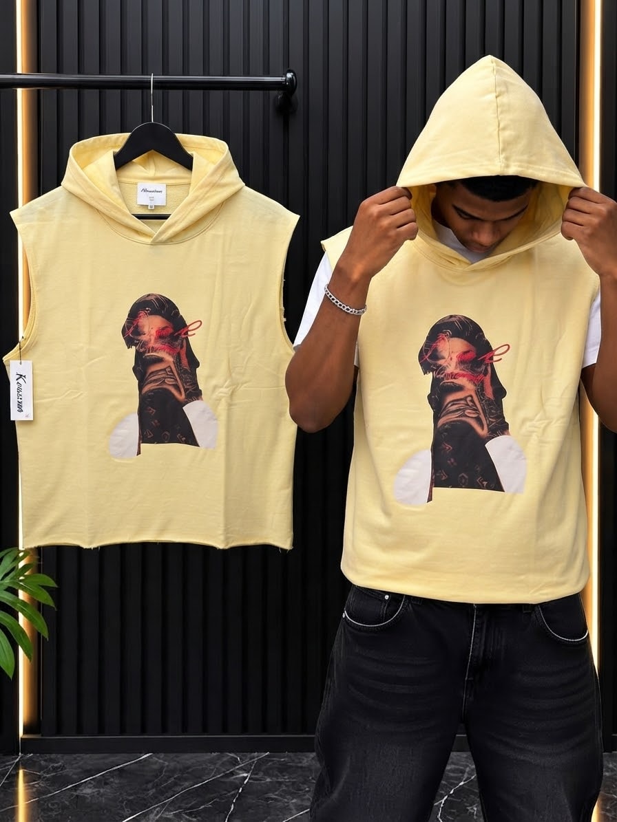Yellow sleeveless cropped hoodie with graphic print shown on model and hanger against black background.
