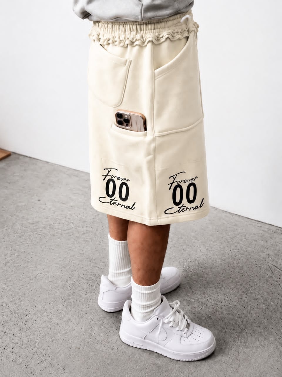 Model wearing cream Forever 00 Eternal cargo shorts with phone in pocket.