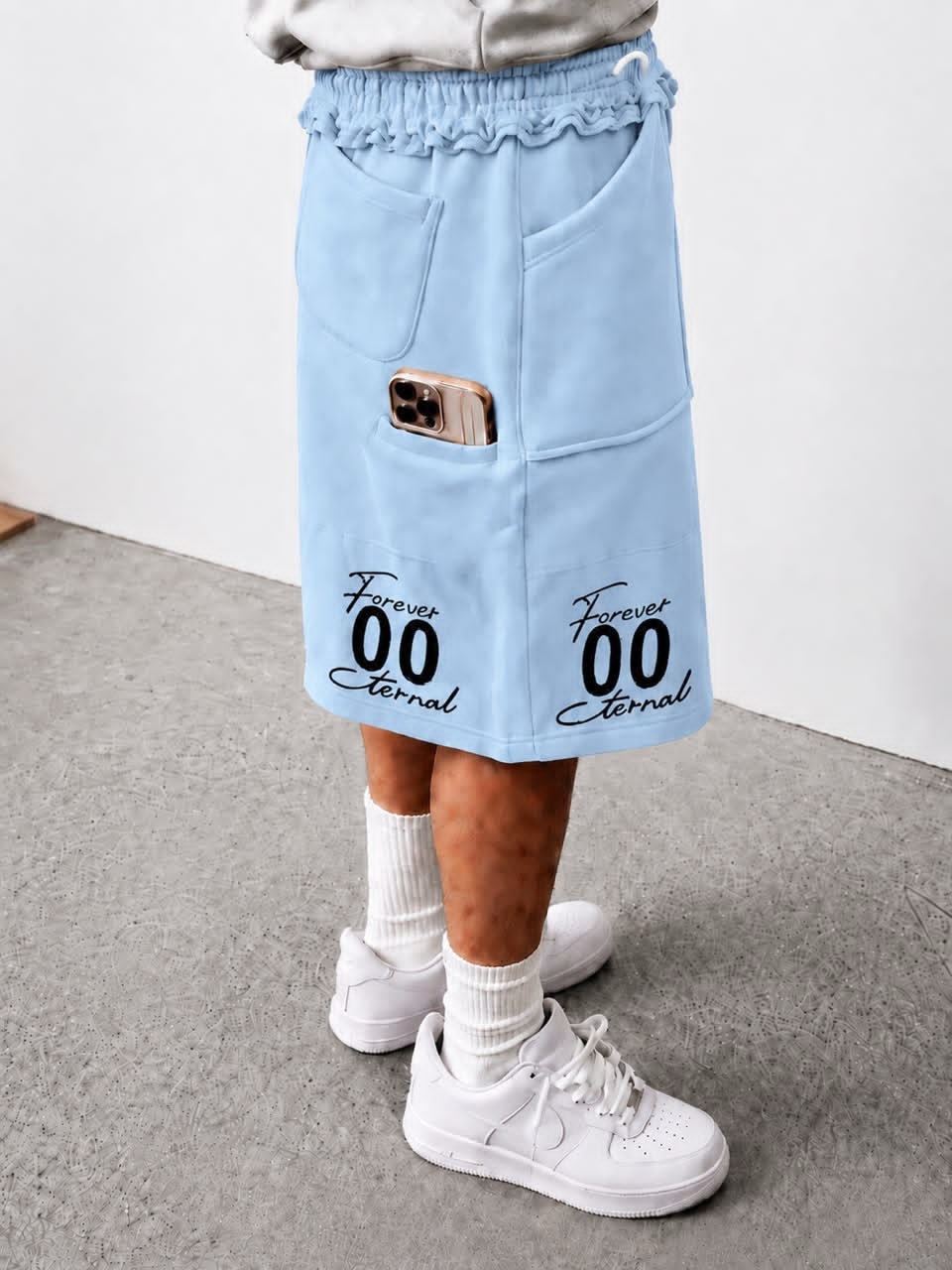 Model wearing light blue Forever 00 Eternal cargo shorts with phone in pocket.