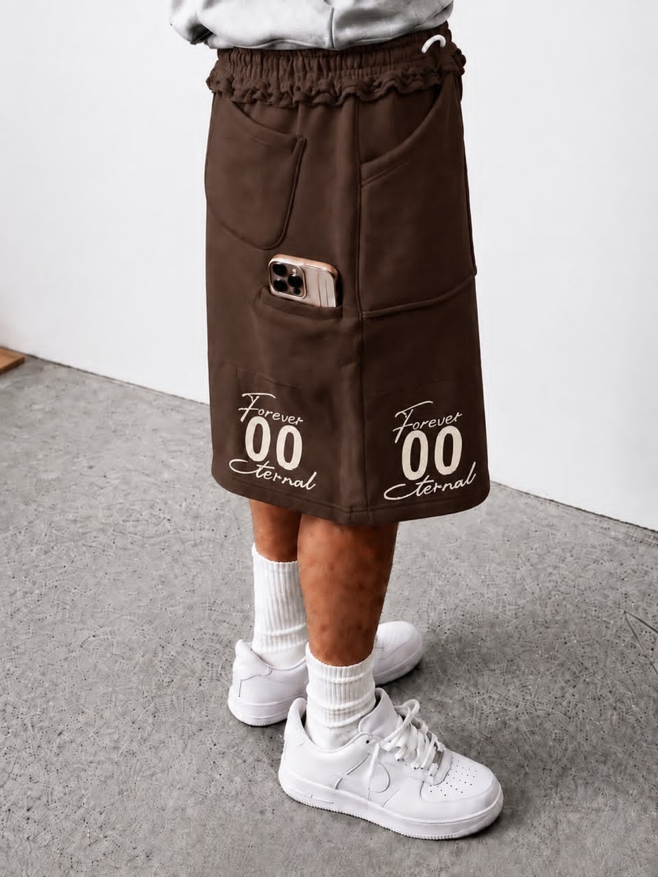 Model wearing brown Forever 00 Eternal cargo shorts with phone in pocket.