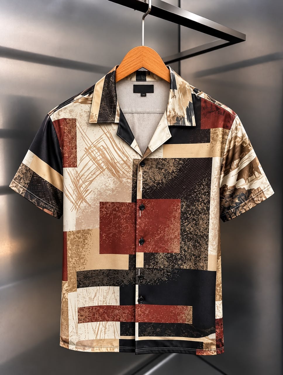 Front view of short-sleeved satin shirt with black, white, and gold mountain landscape print.