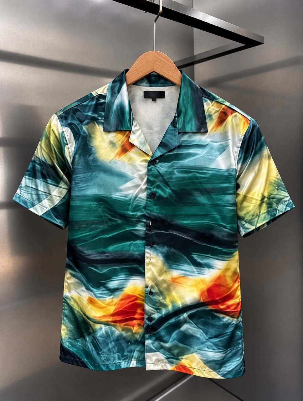Front view of short-sleeved satin shirt with abstract black, white, beige, and maroon brushstroke print.
