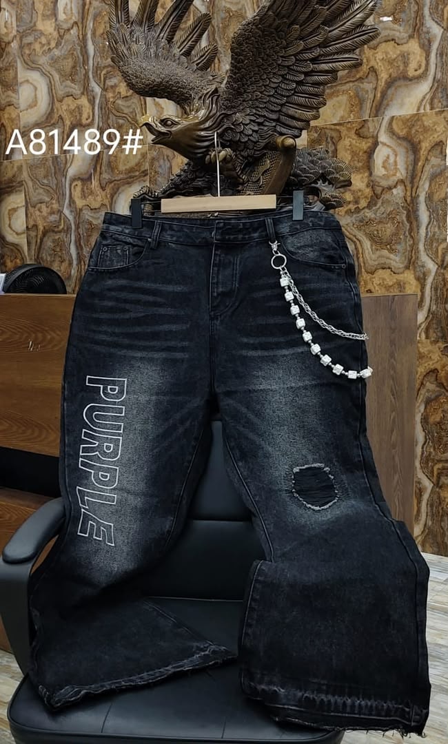 Black baggy jeans with vertical PURPLE text print on leg and white beaded chain.