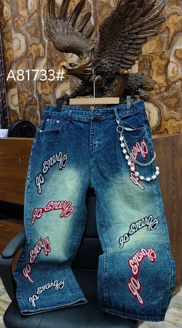 Blue baggy jeans with multiple red and white go Energy text prints and beaded chain.