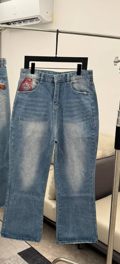 Red flare jeans with black cursive script print on the leg, front and back views with tags.