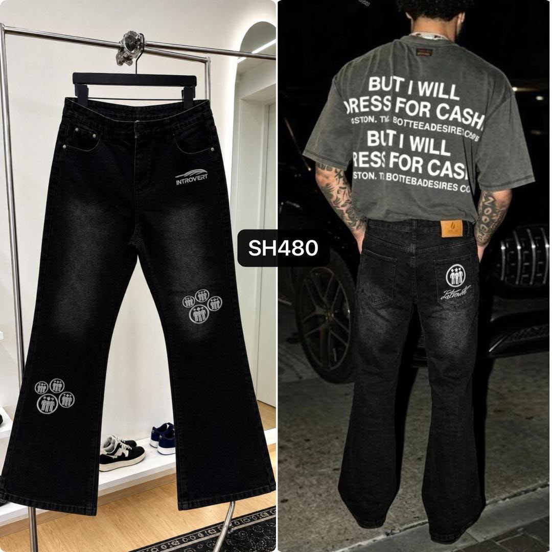 Black jeans with white INTROVERT text and circular figure graphics, shown flat and on model wearing t-shirt.