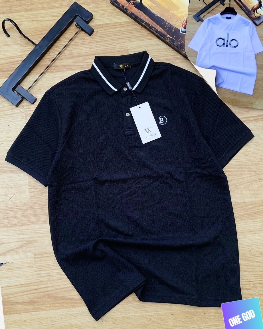 Black luxury polo shirt with contrast collar and circular chest logo.