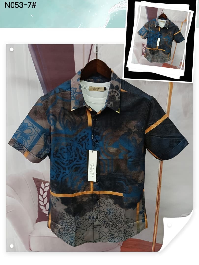 Blue brown and gold patterned short sleeve shirt on hanger with inset image.