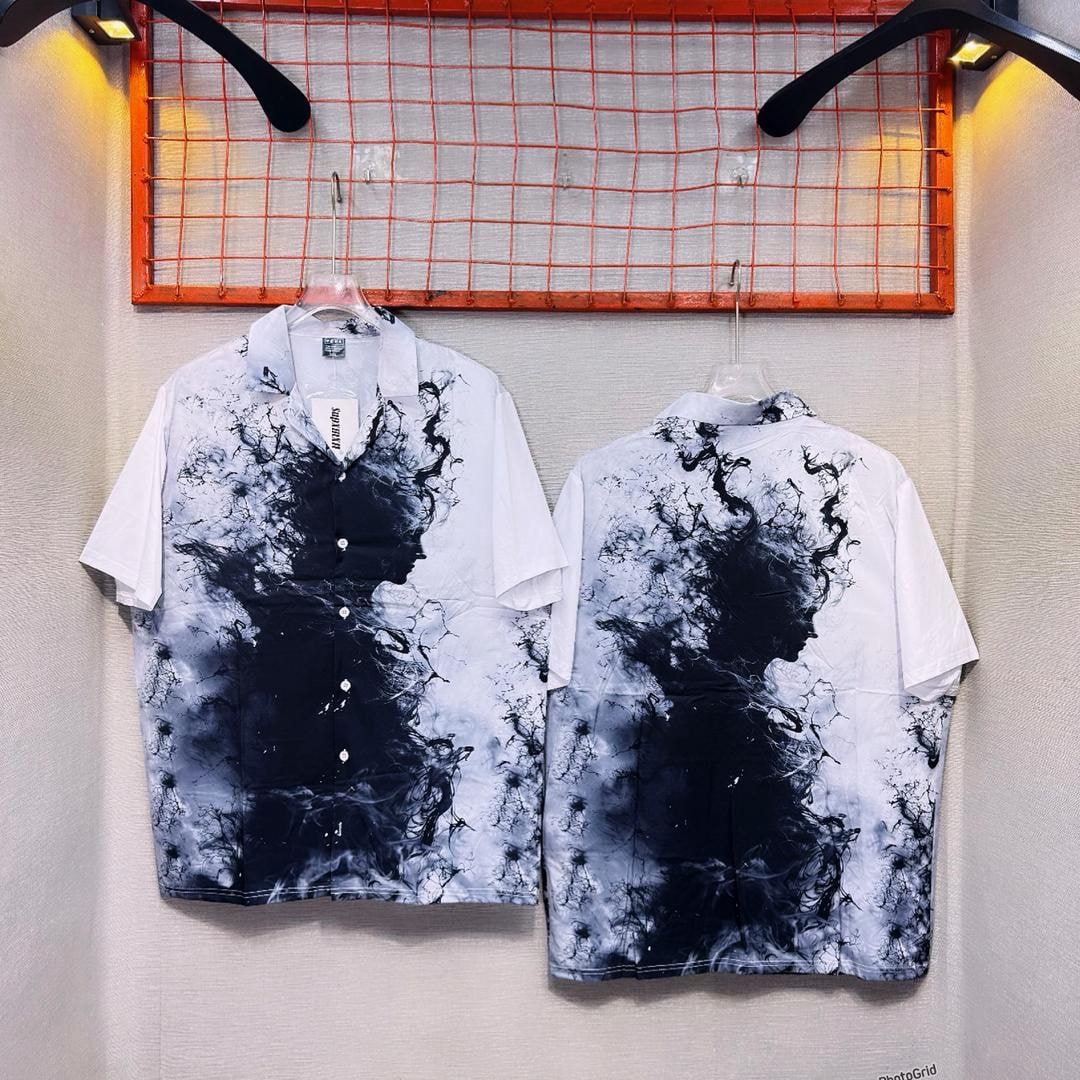 Front and back views of white short sleeve button-up shirt with black ink splash abstract pattern.