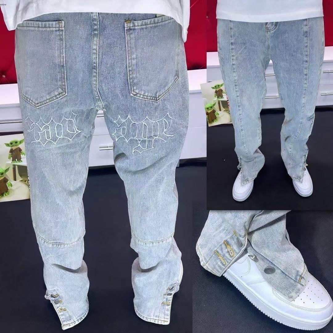 Model wearing light blue baggy jeans with white Savage embroidery on back pockets and gold zipper details at ankles.