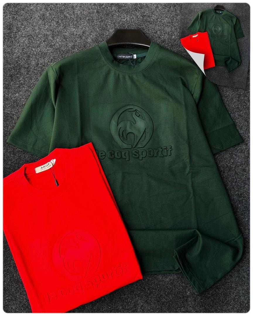 Green and red Le Coq Sportif t-shirts with embossed rooster logo and text.