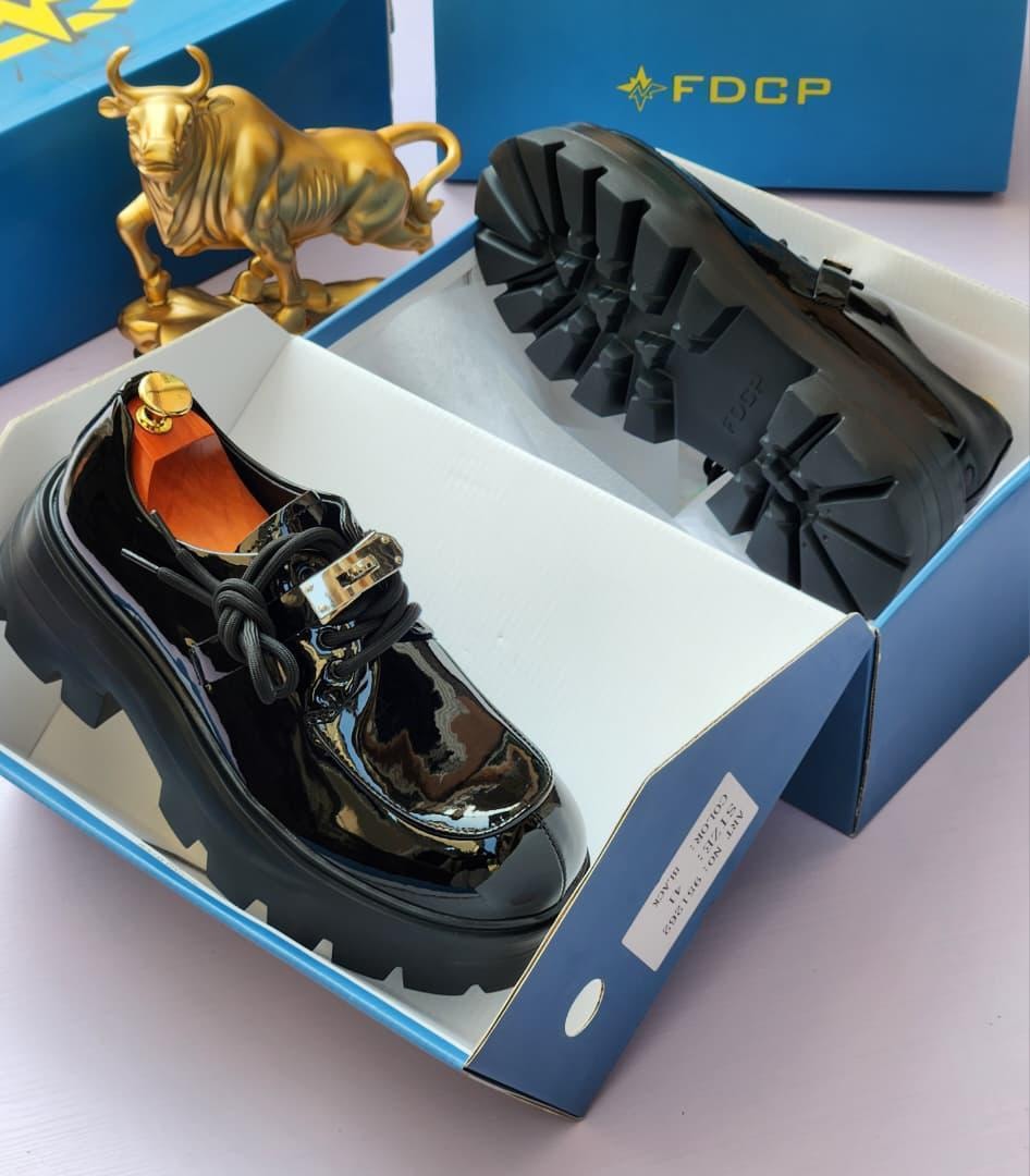 FDCP black glossy chunky platform shoe in blue branded box showing orange insole and thick lug sole.