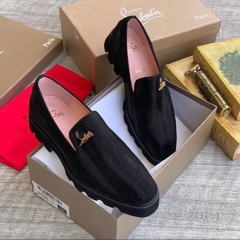 Black Christian Louboutin textured loafer with gold logo inside branded box with red dust bag.