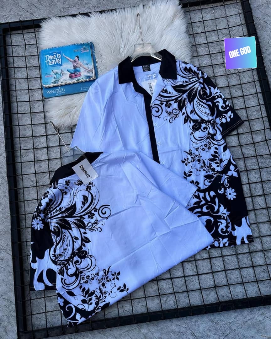 Light blue shirt with black floral patterns and matching shorts on grid surface.