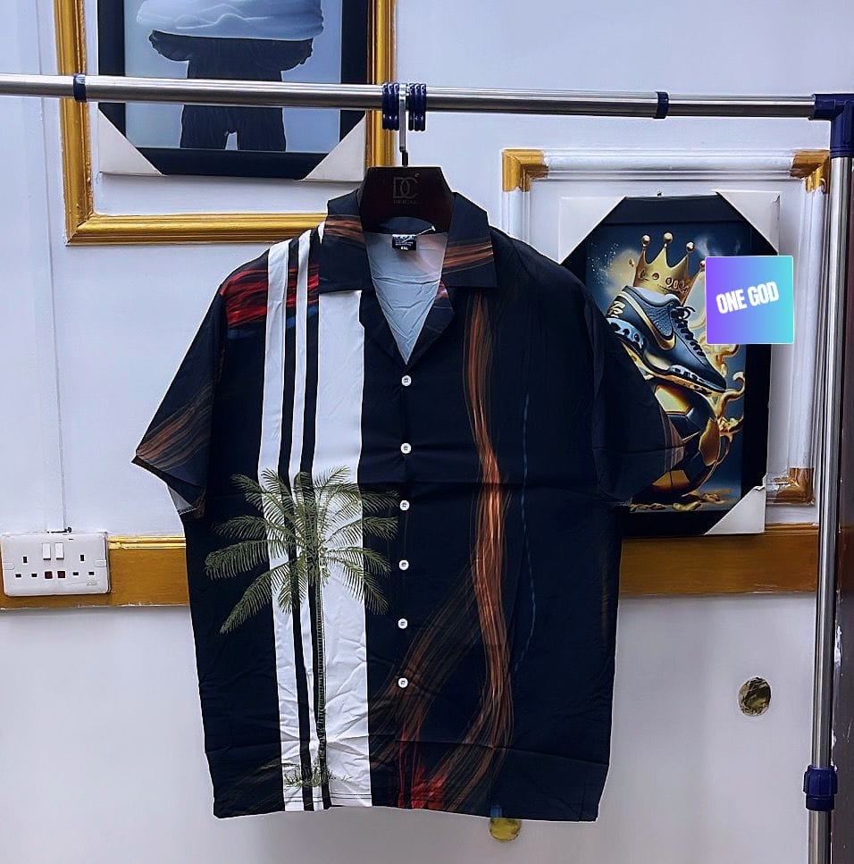 Black short sleeve shirt with white stripe and palm tree hanging up.