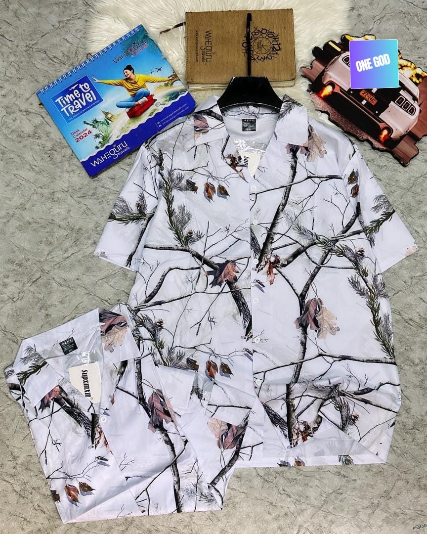 White shirt and shorts with tree branch and leaf print flat lay.