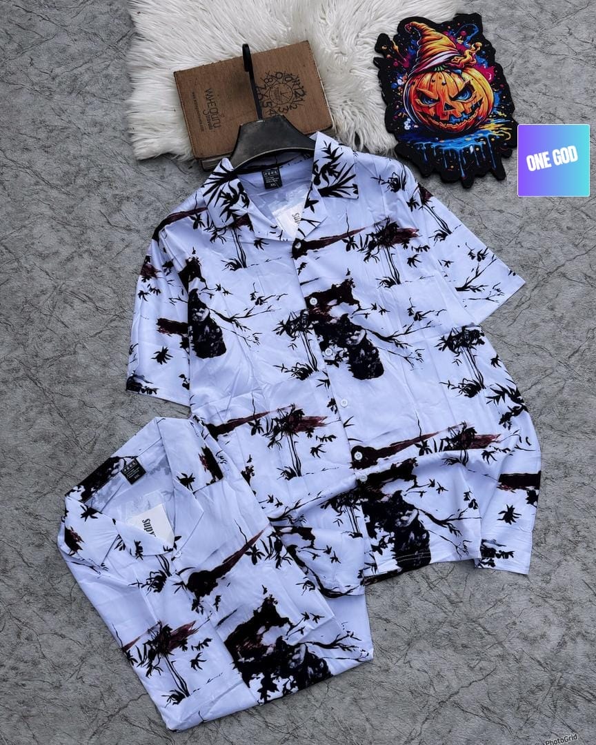White shirt and shorts with dark tree and branch print on textured surface.