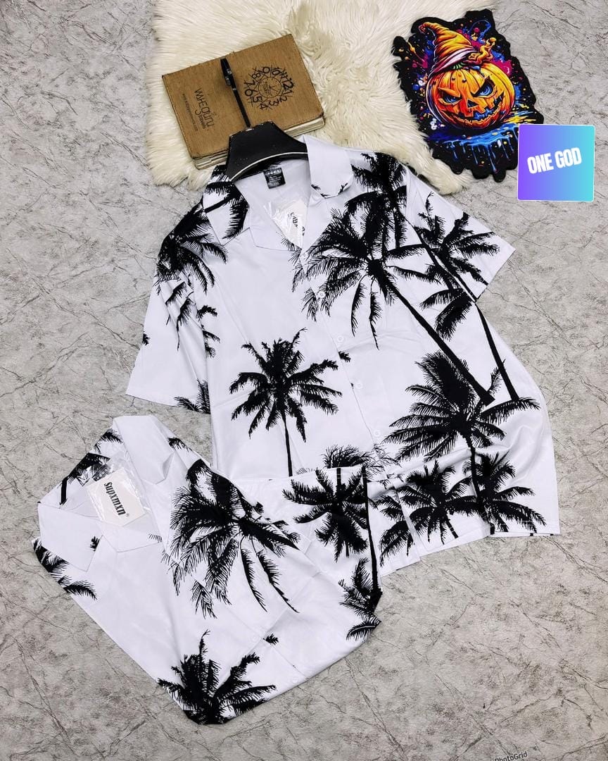 White shirt and shorts with black palm tree print laid flat.