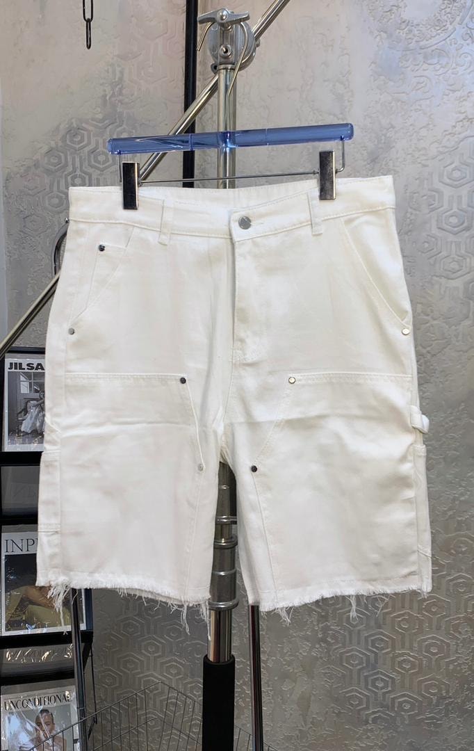 White cargo denim shorts with flap pockets hanging on a display stand.