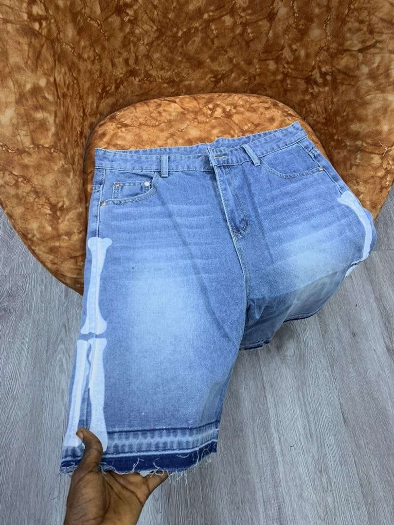 Light blue baggy denim shorts with white bone print down the side and frayed hem.