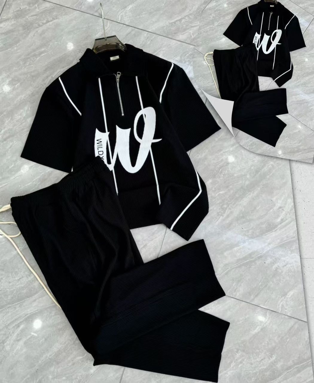 Black ribbed two-piece set with zip polo shirt and matching pants.
